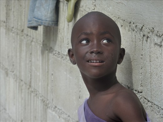 This young boy gazes hopefully at the walls of an unfinished orphanage.