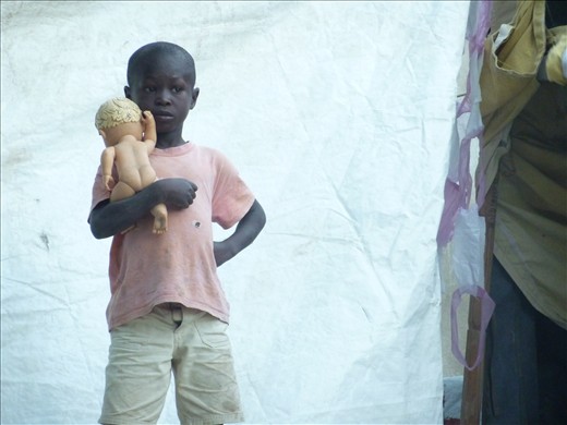 A boy lovingly cradles a doll at a memorial service for the 2010 earthquake.