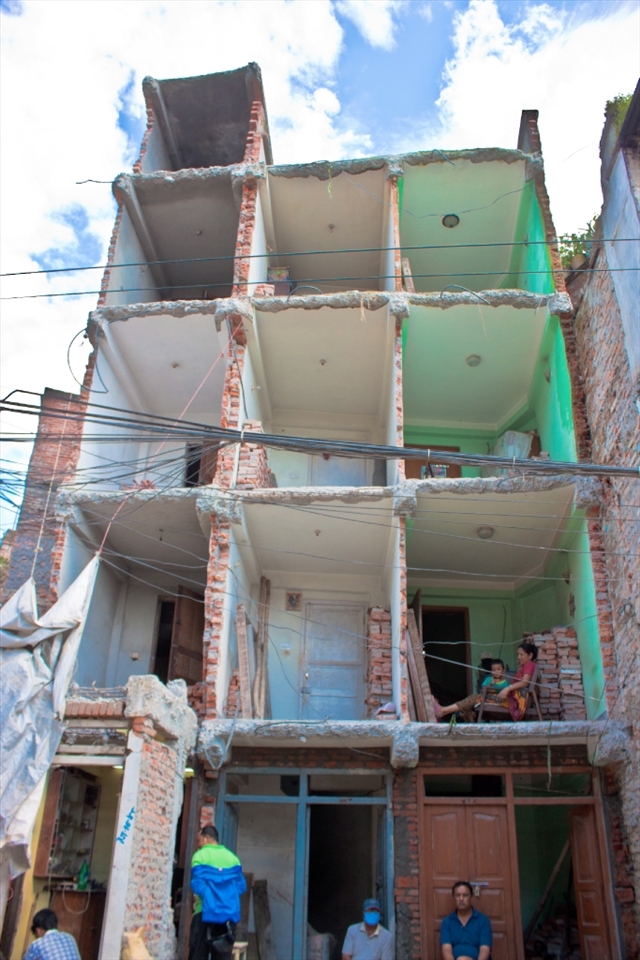 This photo is of a house that has lost about half of its front. I thought it was a great subject cause it shows a lady and her child in one of the rooms. It also shows whats really happening. There goes your privacy out of the window