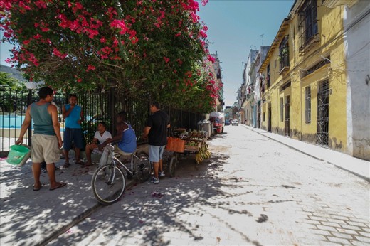 Havana, Cuba. Locals are making small talk with the owner of a fruit cart. The price of the fruits offered for sale is adjusted for tourists; a local could not afford to pay the amount asked by the fruit cart owner.