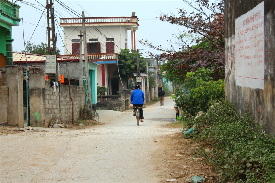 A woman in blue is riding an old bicycle after a long day working.