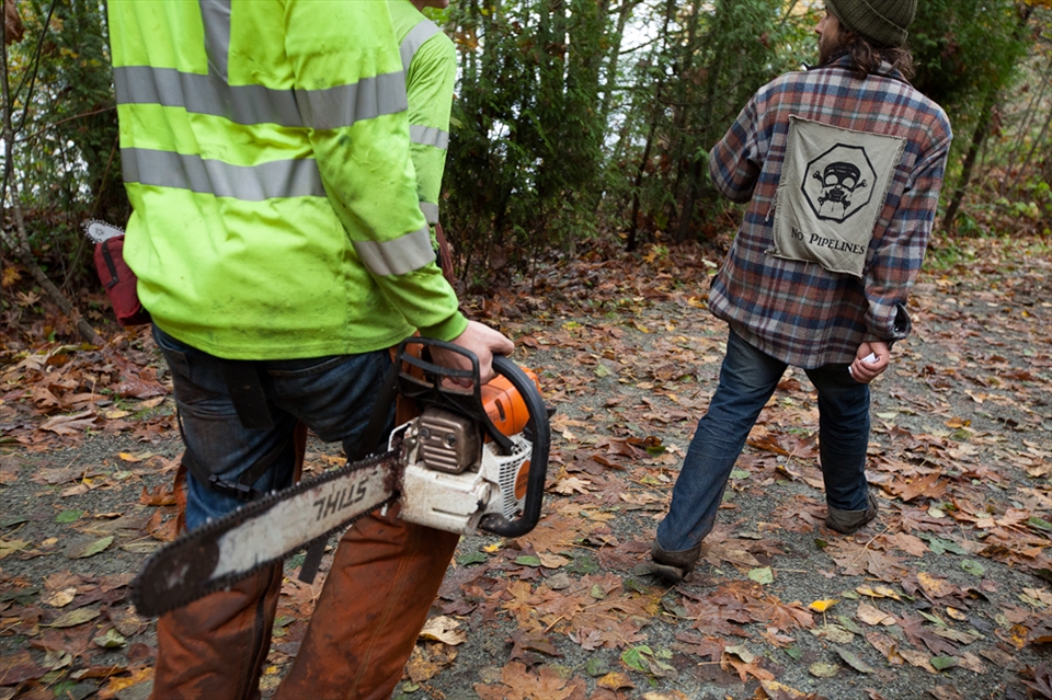 After the first incident, anti-pipeline supporters have monitored the mountain 24/7. In this image, a protestor escorts Kinder Morgan employees out of the forest, where they were about to remove more trees. 