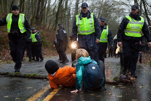 After the injunction was granted, protestors did whatever they could to prevent Kinder Morgan from working. In this image, two protestors lay on the ground in front of a log they placed on the road to prevent the Kinder Morgan work truck behind the police from getting up the road. So far, over 30 people have been arrested from crossing the injunction line. The fight continues... 