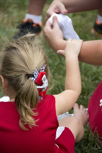 A child was cold and needed her mom to rub her feet and put her socks on. 