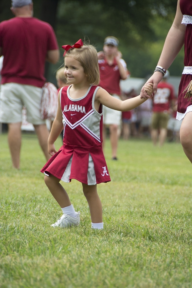 Distracted by moon bounces in the distant, a child ran with her mom to play.