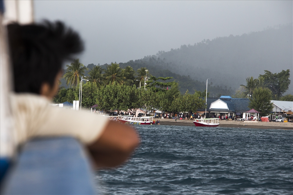 A man stares at the Lombok Port, as the boat and a storm approaches.