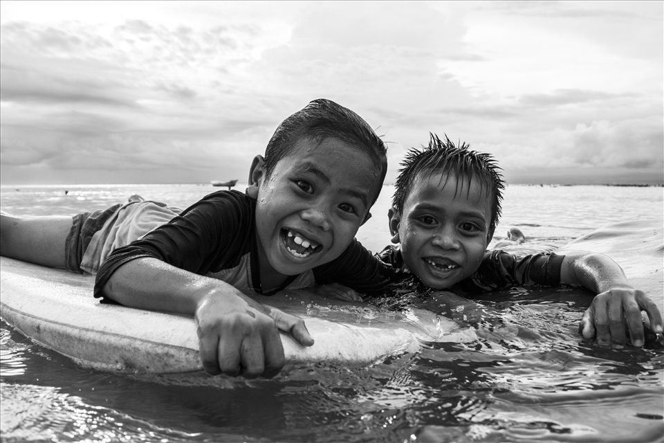 Kids playing with an old board at Nusa Lembongan Island.