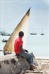 A boy sits on an upturned fishing dhow waiting for the fishermen to return.: by cotomono, Views[358]