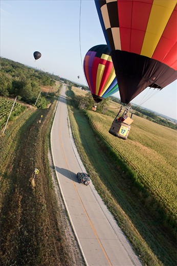 Balloon pilots and co-pilots navigate using maps, GPS, and communications via radio with chase vehicles below. They are given the coordinates of multiple targets, which they must fly as close to as possible.  They then throw baggies marked with their number, which judges measure for distance from target. Indianola, Iowa.