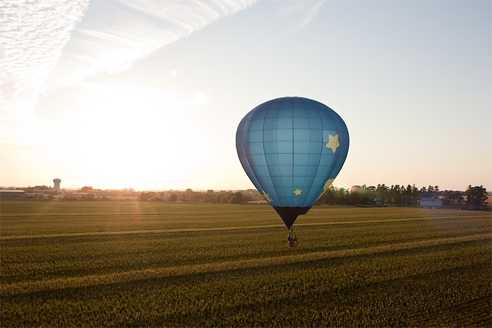 After completing the evening competition task, some balloons enjoy a leisurely evening flight. Here “Stellar” is still in a race to beat the setting sun. Flight elevation and landing zone restrictions can make it difficult to find a spot to land. Indianola, Iowa.