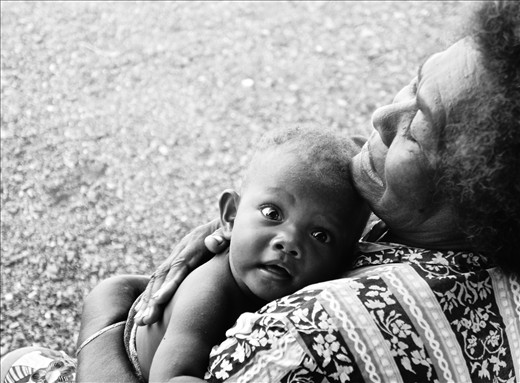 Grandmothers often take care of young ones whilst mothers work in the garden.