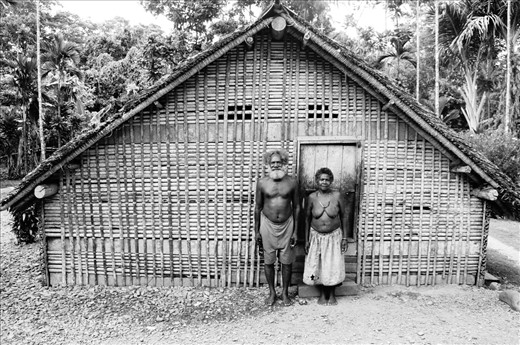 Chief Bungana and his wife stand outsite their home. Nangali Village.