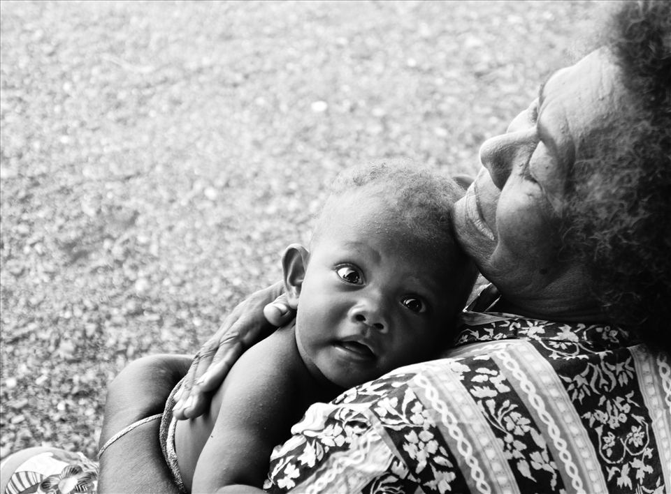 Grandmothers often take care of young ones whilst mothers work in the garden.