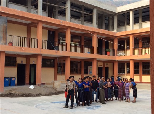 School kids playing ball. Notice the third floor of the school is not finished. Not finishing buildings is a very common pattern here. 
