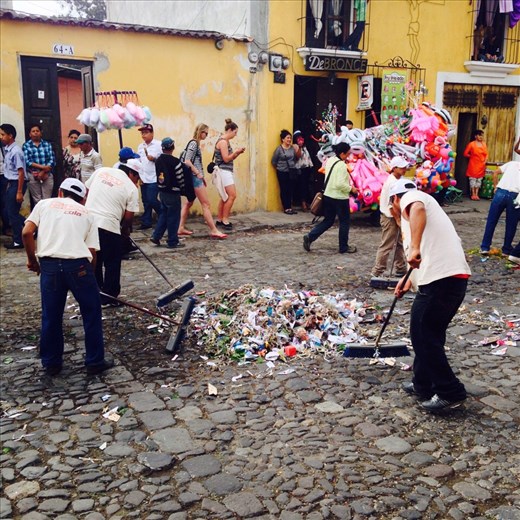 The trash guys cleaning up our carpet after processions goes by. 