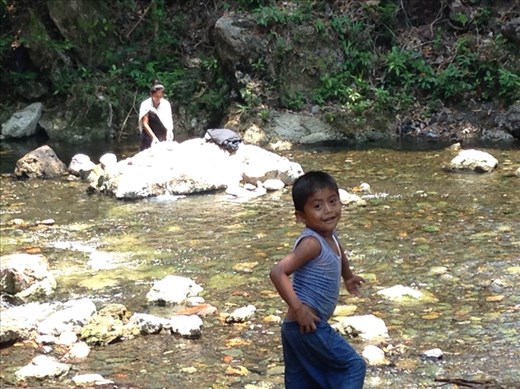 Kids playing while moms do the laundry down the river 