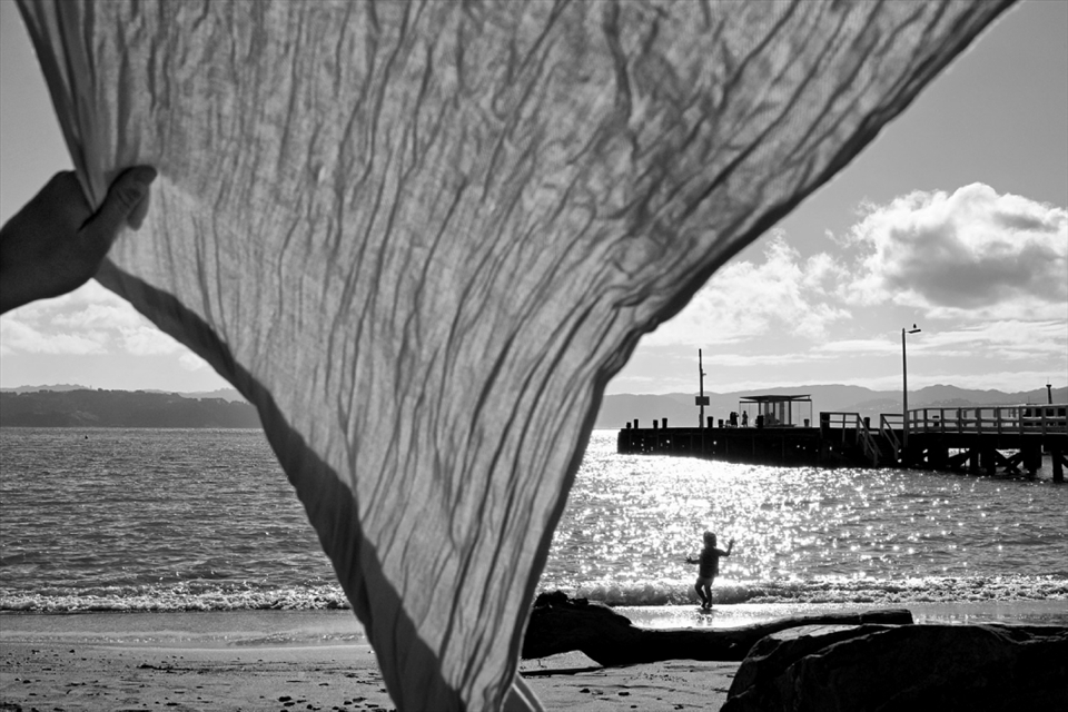 Getting sand out of a scarf in Day's Bay, Wellington. The bay is just a short trip across the harbour by ferry from the central city. October 2012. 