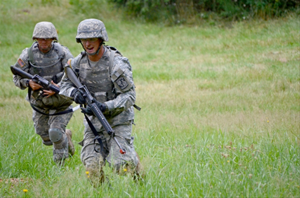 Alpha team Cadets lead their team across a field at the live fire combat training course. Cadets are expected to move as if they are on the front lines of combat. That means running low, diving and rolling their way across open areas. 