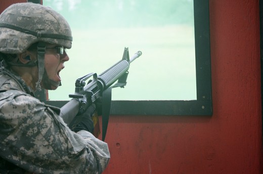 A Cadet calls for cover after running out of ammo during a combat simulation. Cadets use live ammo during these simulations and are expected to reload or fix a jammed weapon under pressure. 