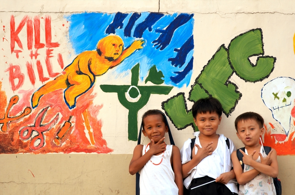 Reproductive Health Bill Opposed: Just a few meters away from the cathedral is an elementary school with a mural showing opposition to the Reproductive Health Bill (now a law—intended to address the problem of poverty & growing population) of the government; the picture also shows the Catholic church's persuasive 