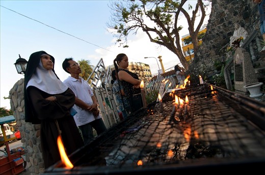 The devotees and religious lighting up candles and offering prayers in a shrine beside the cathedral.