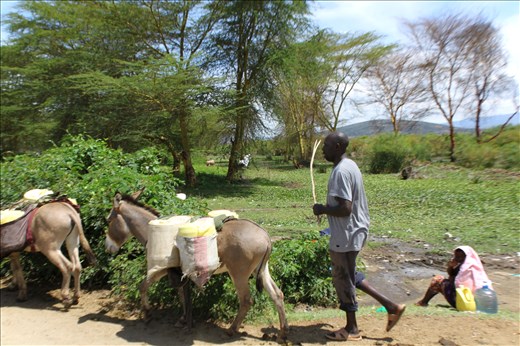 A water seller fills up from the lake, meters away from laundry run off.