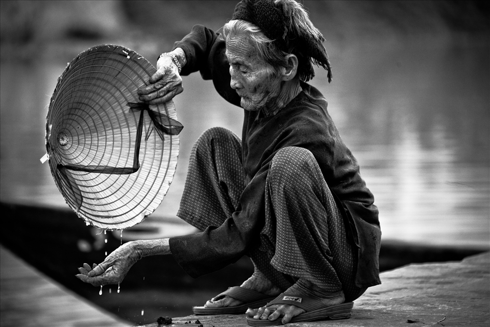 A grandmother washes her hands after preparing fish for a late breakfast.
