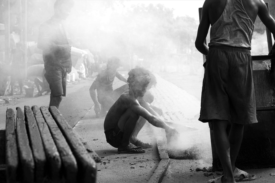 Shambhu and his co-workers get down to business without really caring about any safety norms. As one can see him pouring a sweltering mix of tar and gravel with mere slippers on. No hand gloves, no gumboots, no masks, these workers risk their life everyday for merely 3 dollars.