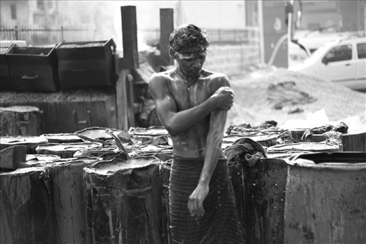 What’s the one way of shrugging off the day’s weight? A refreshing bath. Seen here is, Murari, taking a bath amidst the traffic. He uses tar containers that serve as the walls, providing him little privacy in his intimate moment. Life on the road is like a glass window where everybody tries to peep-in for fun. 