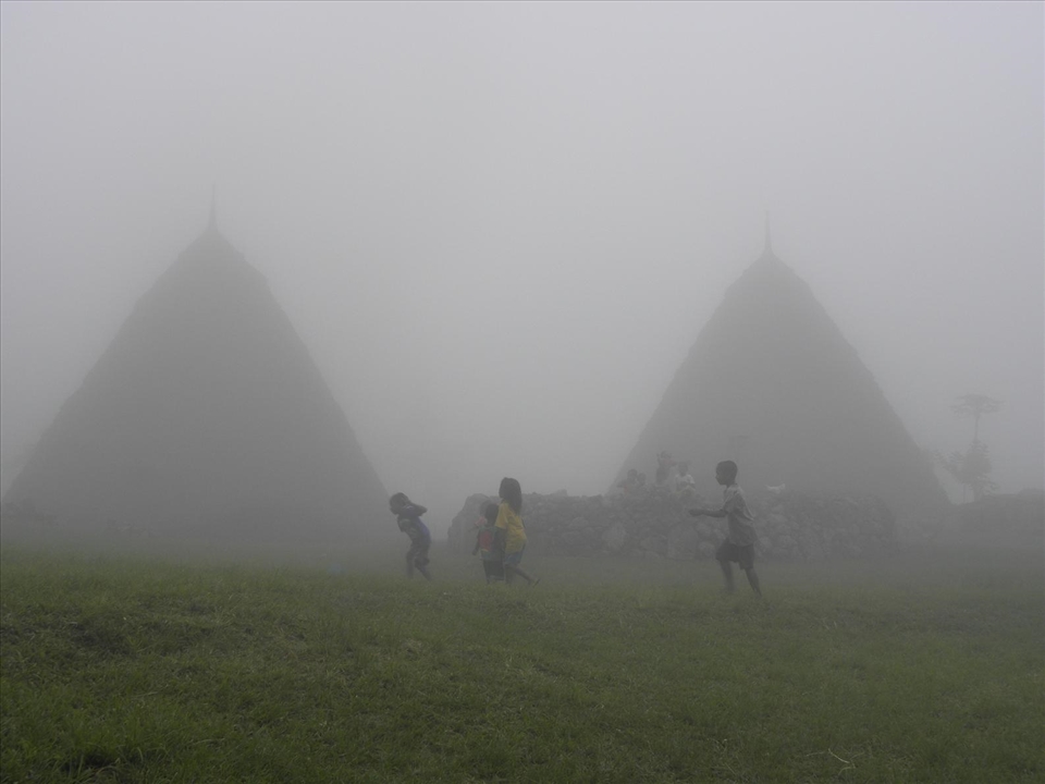 Misty playtime around the central altar in Wae Rebo, a secluded traditional mountain village in West Flores. Since there is no school in the village, the children have to attend the one in the nearest town located 4 hours walking distance from there.