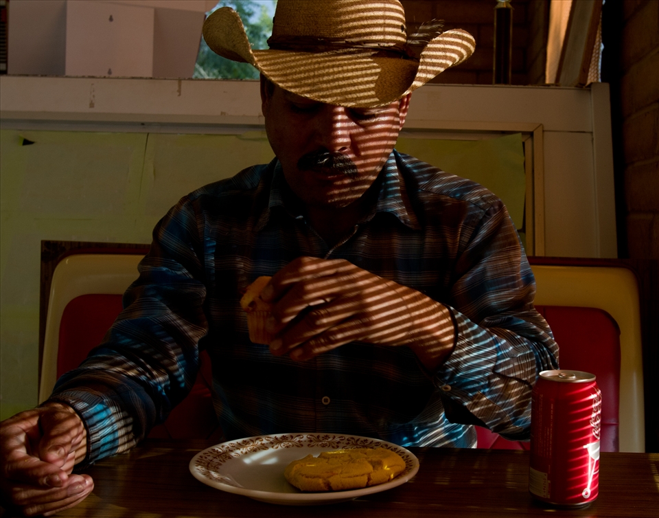 Gabriel, an undocumented immigrant farm worker eats breakfast at a bakery in a small town in New Mexico. He used to visit his family in Mexico regularly, but afraid of permanent deportation he hasn't made the trip in years.
