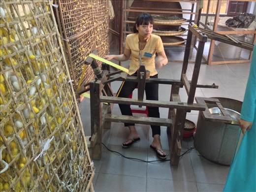 Watching silk fabric made from the worms cocoons at the Thang Loi silk factory.