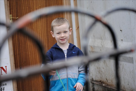 Belfast, Short Strend.
Short Strend is a Catholic enclave in East Belfast, surrounded by the mainly Protestant and unionist neighborhood, from which it is separated by the so called peacewall, a metal barrier 6-7 meters high. Even though many years have passed since the 'Troubles' there objects are thrown from each side to others and sometimes there are aggressions. 
In this picture I was attracted by the profile of the fence, throw which I saw the kid.