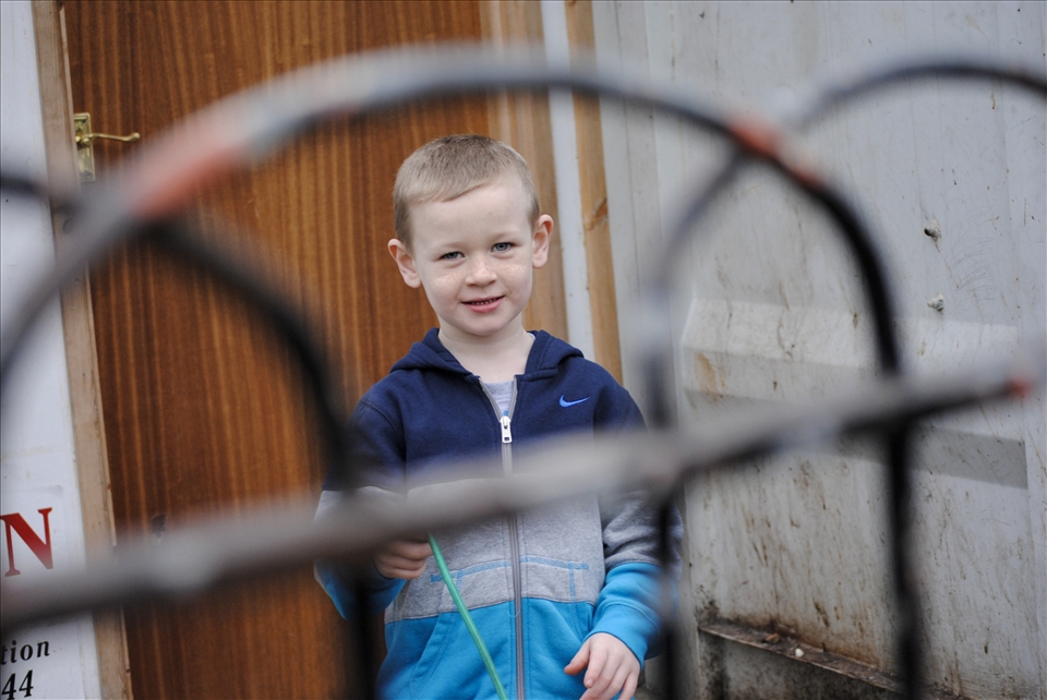 Belfast, Short Strend.
Short Strend is a Catholic enclave in East Belfast, surrounded by the mainly Protestant and unionist neighborhood, from which it is separated by the so called peacewall, a metal barrier 6-7 meters high. Even though many years have passed since the 'Troubles' there objects are thrown from each side to others and sometimes there are aggressions. 
In this picture I was attracted by the profile of the fence, throw which I saw the kid.