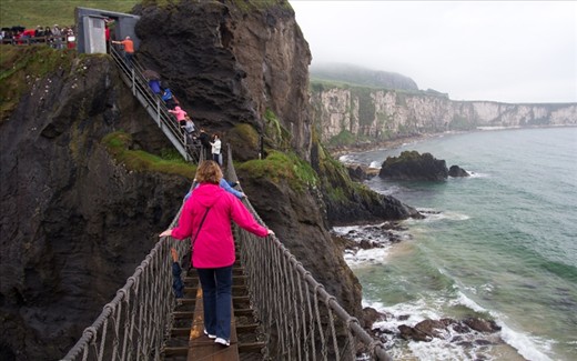 A group of tourists nervously cross the Carrick-a-Rede Rope Bridge after waiting in line in the pouring rain for over an hour. The bridge, which was originally constructed as a safe passage for salmon fisherman from the mainland to the tiny island of Carrick-a-Rede, hangs 98 ft above the ocean.

