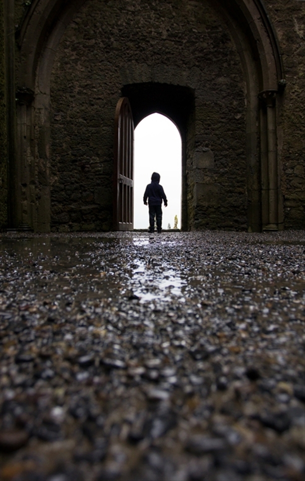Within the Nave of The Rock of Cashel, a curious young boy stands under an arched doorway, gazing out on to the graveyard. Located in the town of Cashel, South Tipperary, the historic landmark attracts approximately 250,000 visitors per year. 