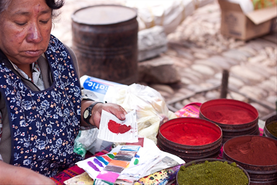 The vibrant colors of the natural dye booth caught the eye of both tourists and locals alike. Here, the vendor demonstrates which natural dyes she mixes to create her preferred  perfect shade of red. 
