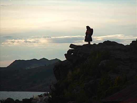 A lady looks out at sunset on Lake Titikaka, the island of Tikelae.