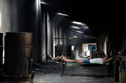 To avoid the hottest hours, this worker lies in this fresh place behind the dhobi ghat.