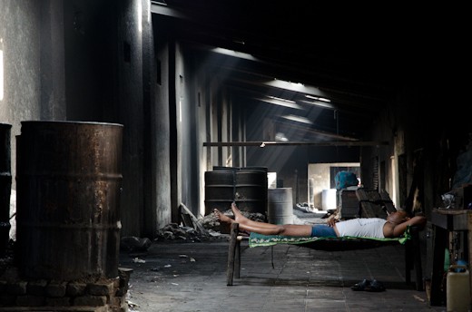 To avoid the hottest hours, this worker lies in this fresh place behind the dhobi ghat.