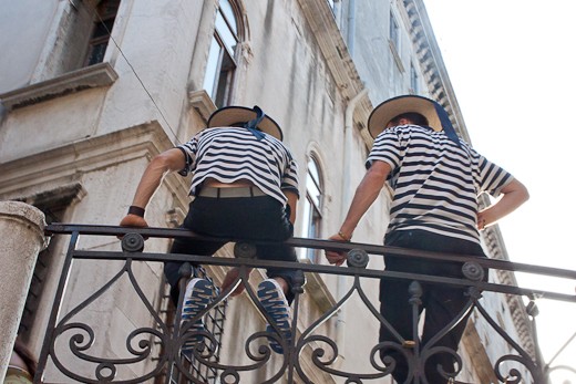 Two gondoliers relax and chat in between shifts.