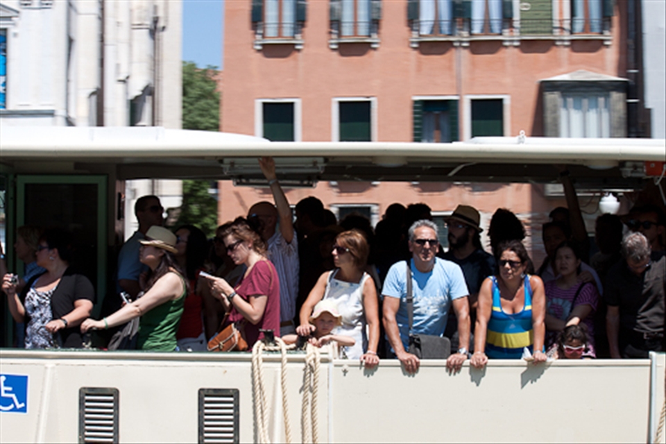 Floating City: Tourists and locals alike cram into a crowded vaporetto on a hot July day.