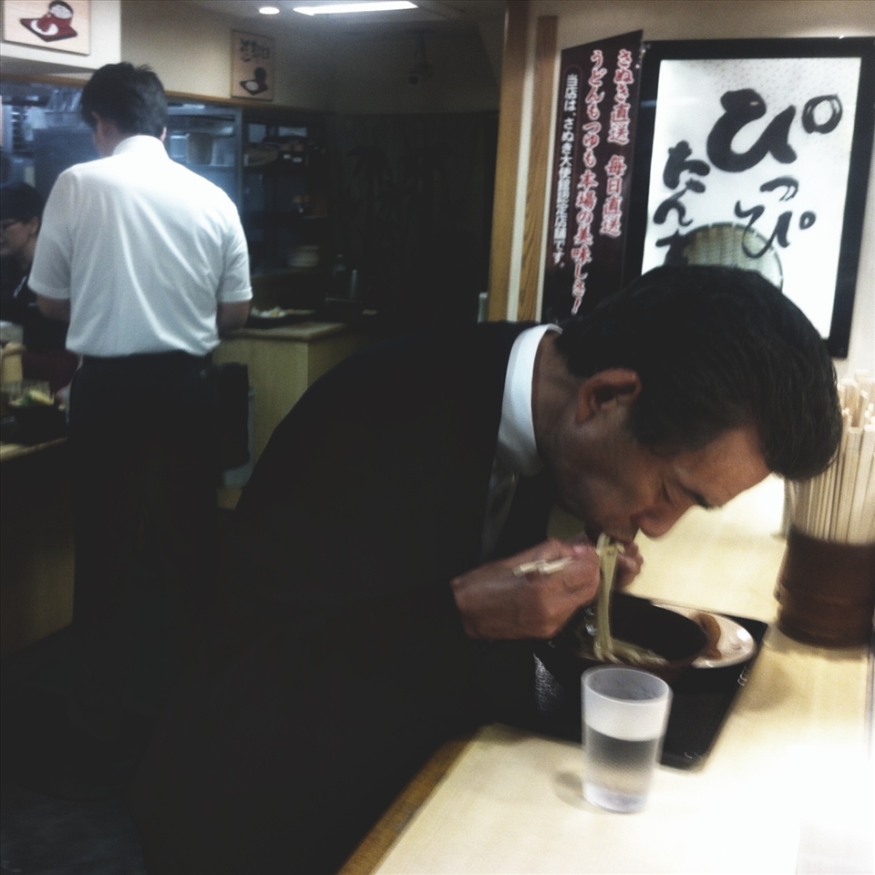 A man eating Udon Noodles, a popular japanese dish.