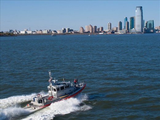 Armed coastguard travels alongside the ferry !