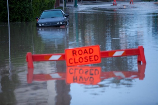Swamped street in downtown Calgary. Cars wrecked, garbage-strewn shops and property damage running into the hundreds of millions.
