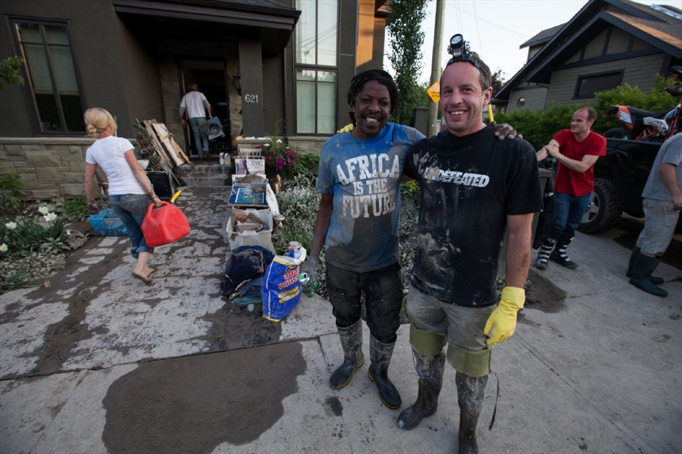Calgarian Spirit in full swing. People pulling together to help flood recovery. Two neighbors sharing the load, stripping basements, hauling out wrecked belongings and salvaging what they can.  