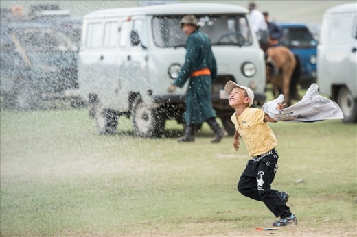 Simple pleasures: a boy revels in the spray from a fire truck, rolled out for the annual Naadam Festival, near the ancient Mongolian capital of Karakorum. The festival draws Mongolians from across the region to socialize and show off their prowess in the traditional sports of cross country horse racing, wrestling and archery.