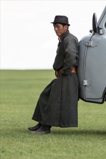 Then and now: a man in traditional dress (save for the natty trilby hat) takes 5 at the Naadam Festival near the ancient Mongolian capital of Karakorum. He leans against one of the thousands of Soviet-era minivans that ferry people and goods around Mongolia. Many are held together with wire, duct tape and sheer force of will
