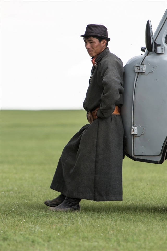 Then and now: a man in traditional dress (save for the natty trilby hat) takes 5 at the Naadam Festival near the ancient Mongolian capital of Karakorum. He leans against one of the thousands of Soviet-era minivans that ferry people and goods around Mongolia. Many are held together with wire, duct tape and sheer force of will