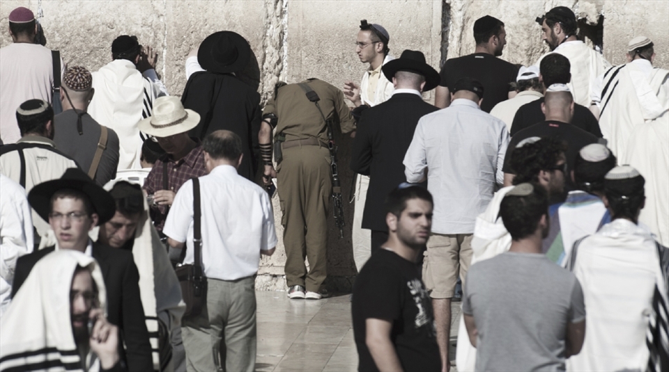 A jewinsh soldier praying at the foot of the wailing wall